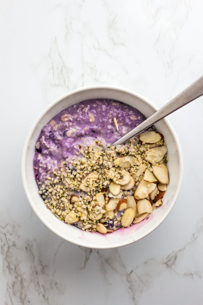 blueberry overnight oats with hemp seeds and almond slices on top
