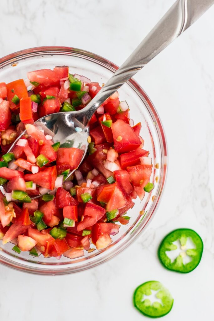 overhead shot of freshly made tomato salsa in a clear bowl