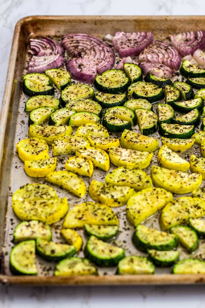 sheet pan full of roasted red onion, zucchini and yellow squash