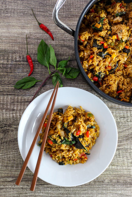 vegetarian thai basil fried rice in the pan and on a white plate with chopsticks on top