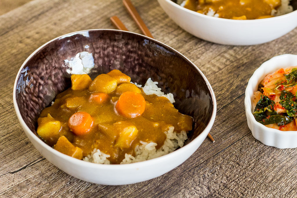 A bowl of Japanese Pork Curry over rice with side of kimchi