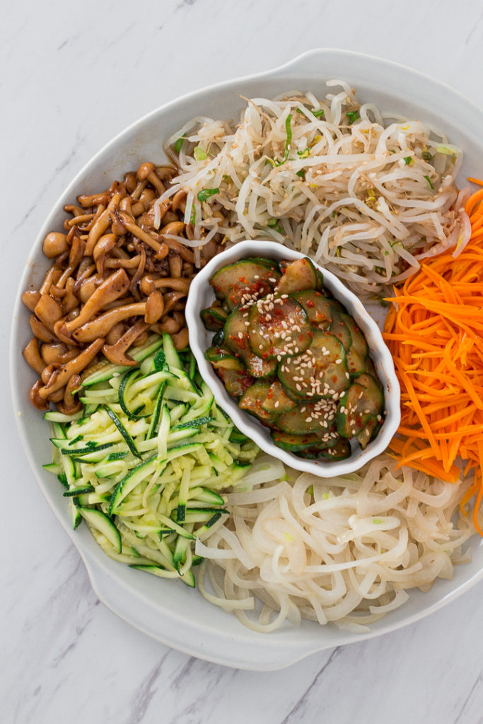 Ingredients for bibimbap - bean sprouts, carrot, onion, zucchini, mushroom, and cucumber kimchi