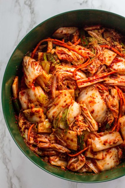 salted napa cabbage and vegetable with the sauce mixed in in a big bowl