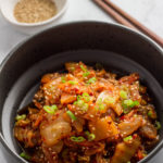 stir fried kimchi in a black bowl