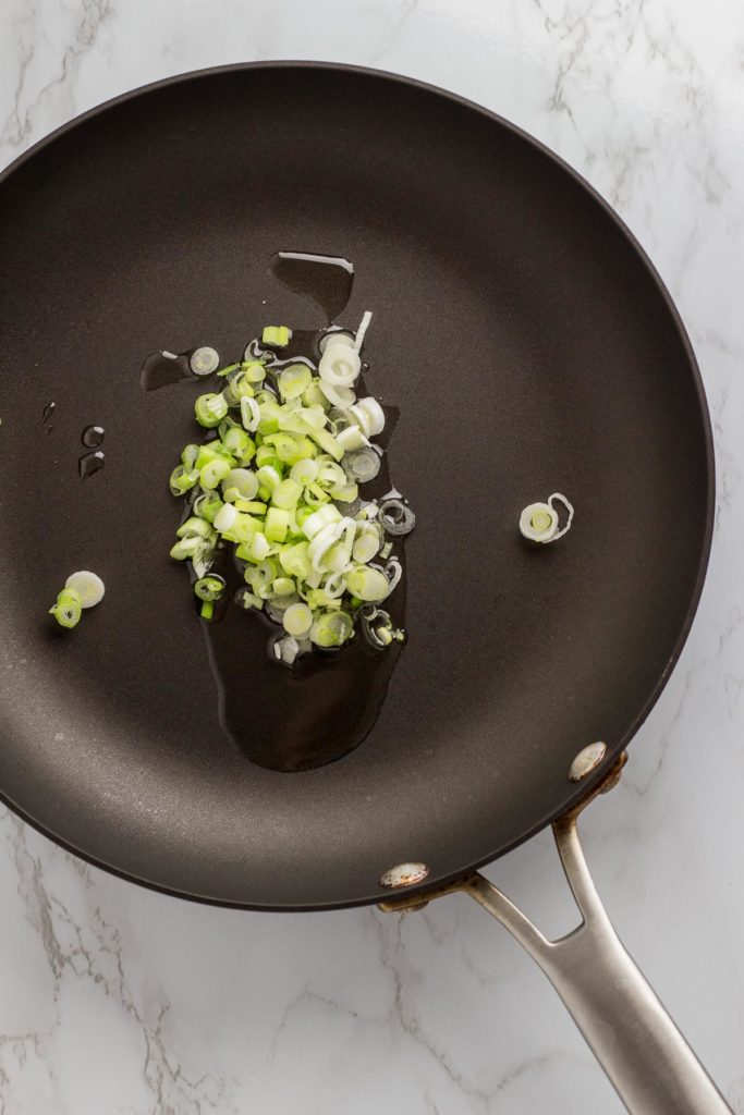 Chopped green onion with grape seed oil in a frying pan for fried kimchi