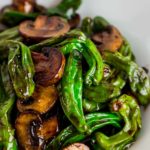 Close up shot of stir fried shishito pepper and mushroom slices