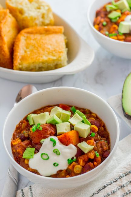 two bowls of winter squash chili with corn bread on the side