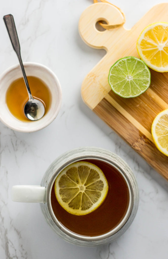 over head shot of cold fighting tea with lemon and honey next to prepared tea