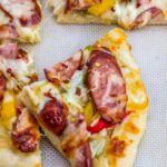 close up shot of a slice of pizza with chicken sausage