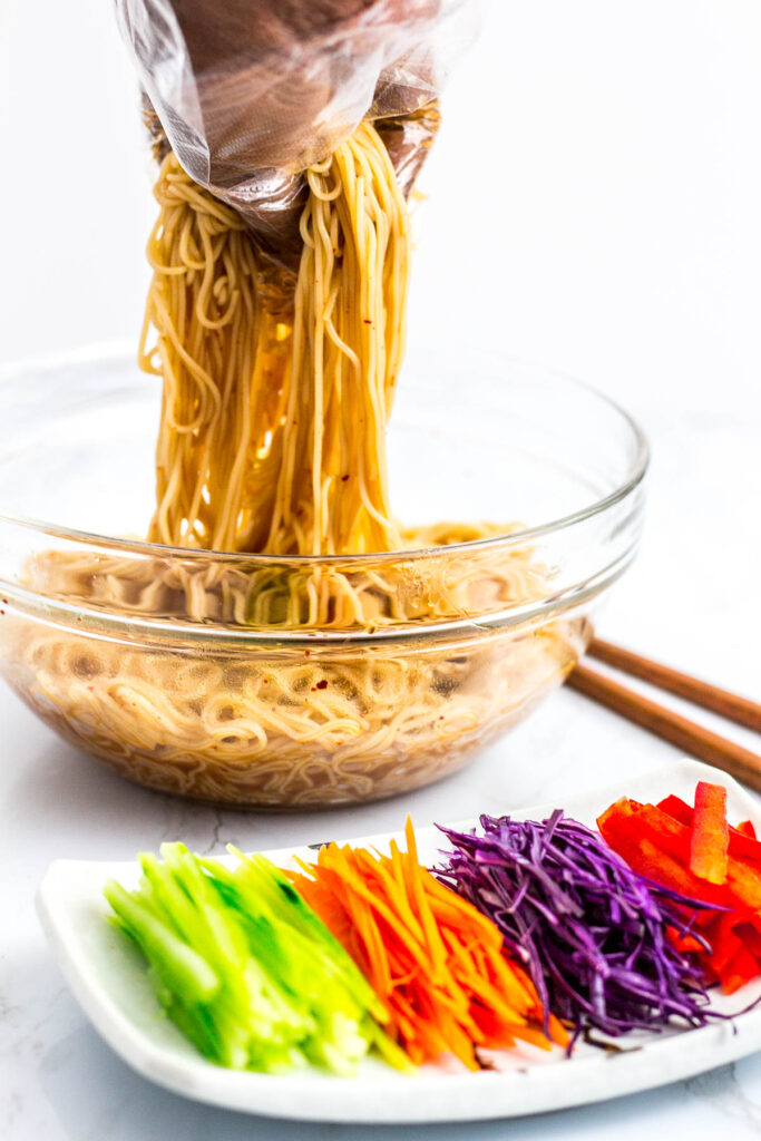 mixing somen noodle with the sauce, vegetable toppings are on the plate in front