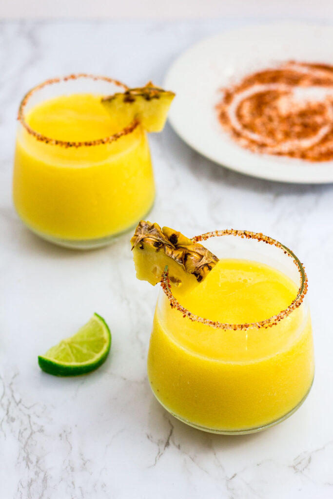 two glasses of margarita with Tajin salt on the plate