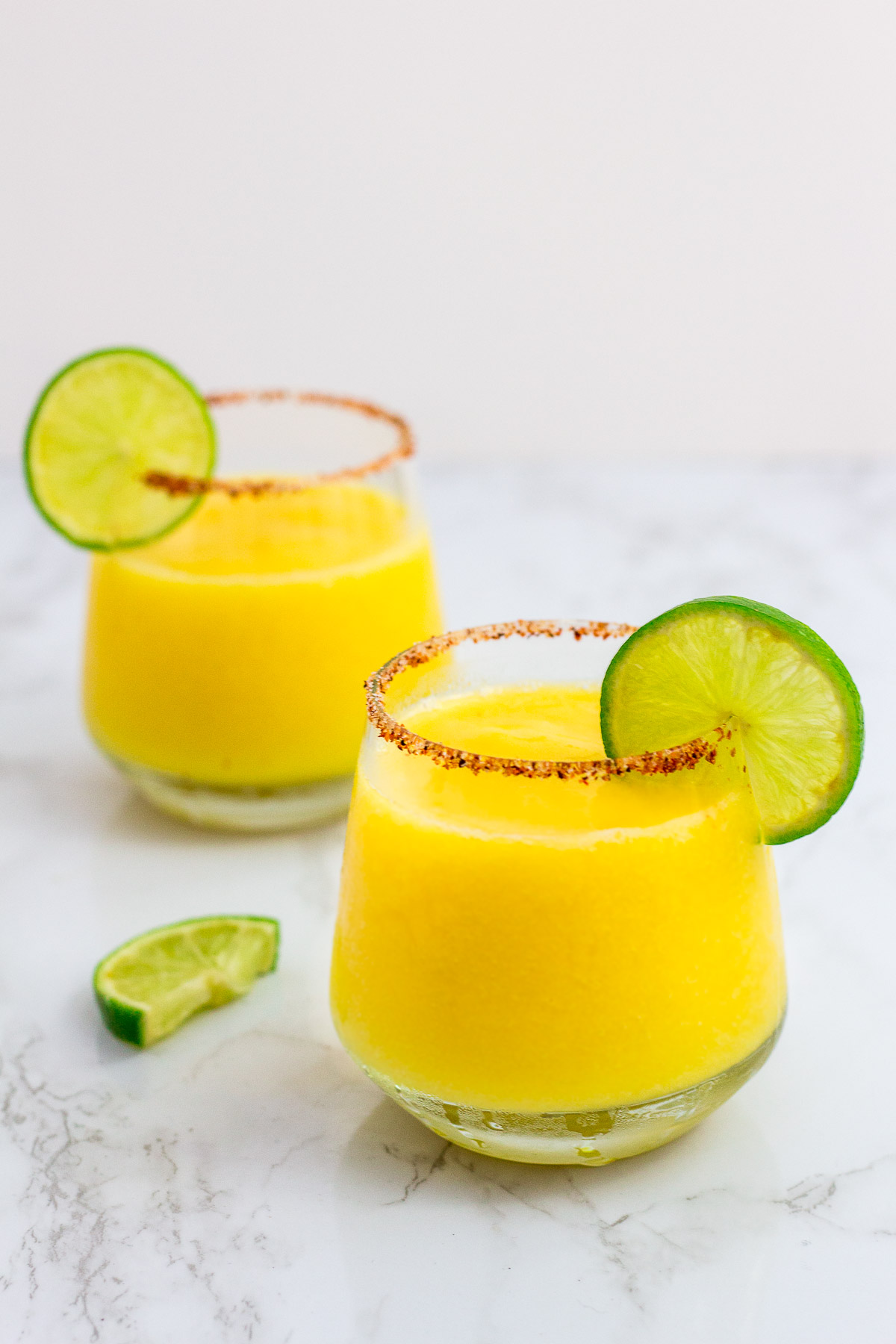 two frozen margarita with lime garnish