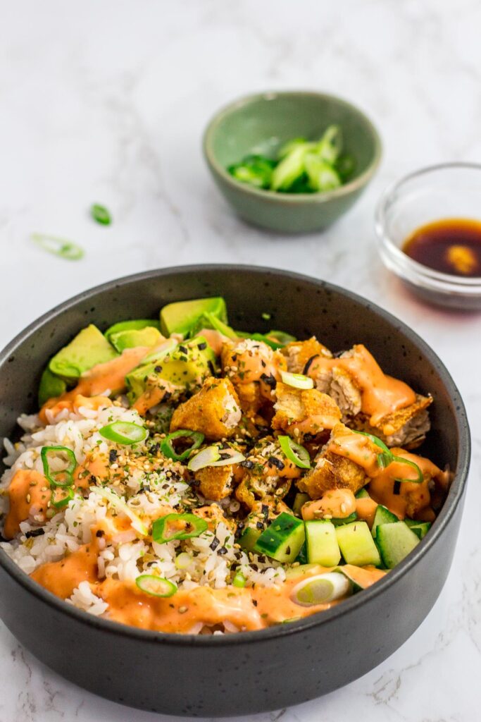 a vegan sushi bowl with spicy mayo on top