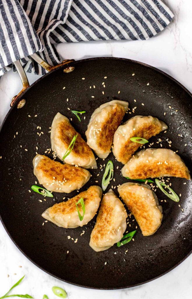 overhead shot of pan fried mandu/dumplings in the pan