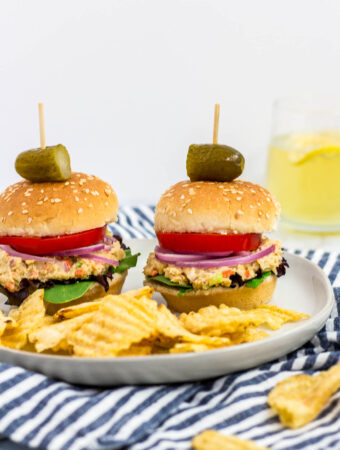 two mini canned chickpea salad sandwiches on a plate with some potato chips