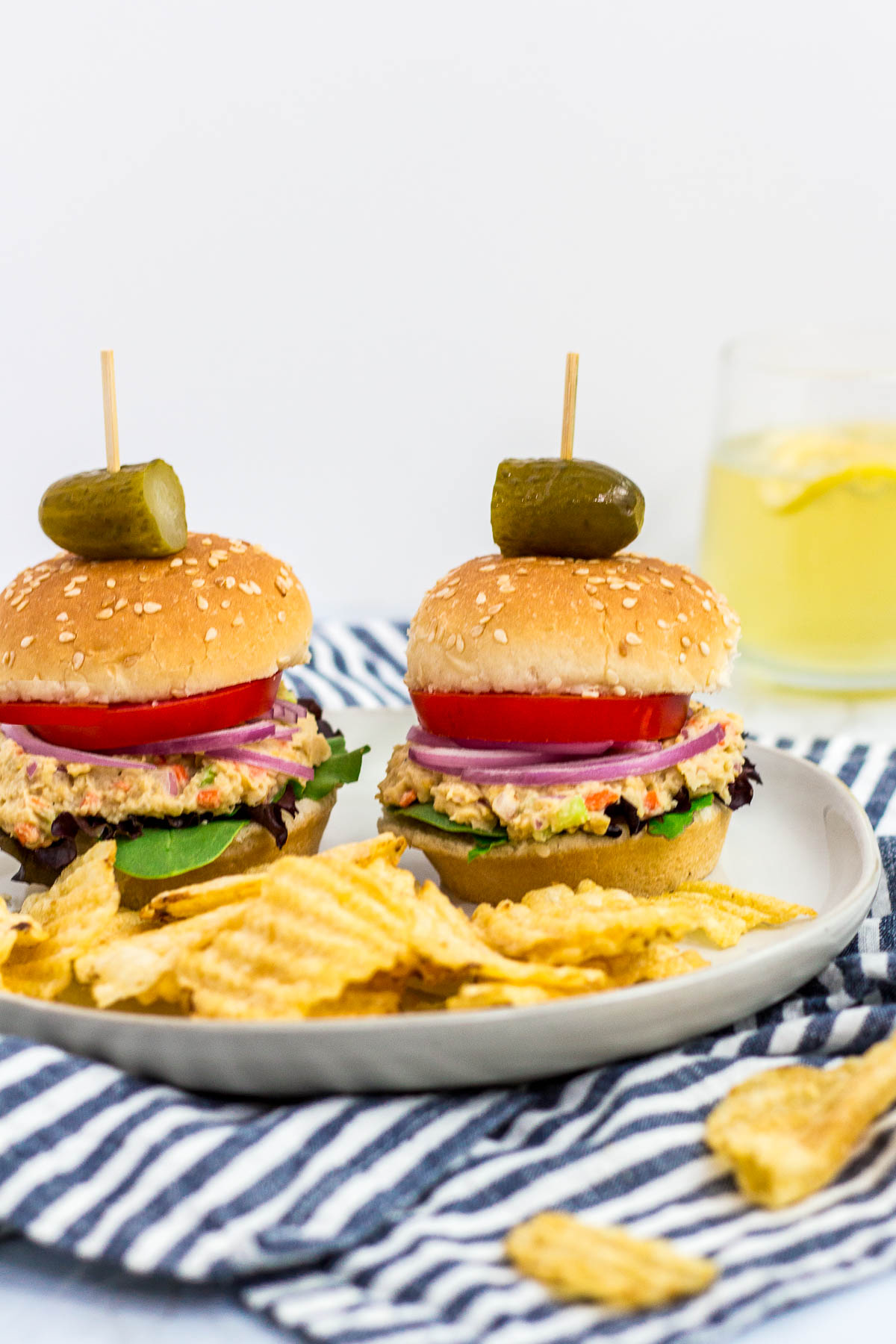 two mini canned chickpea salad sandwiches on a plate with some potato chips