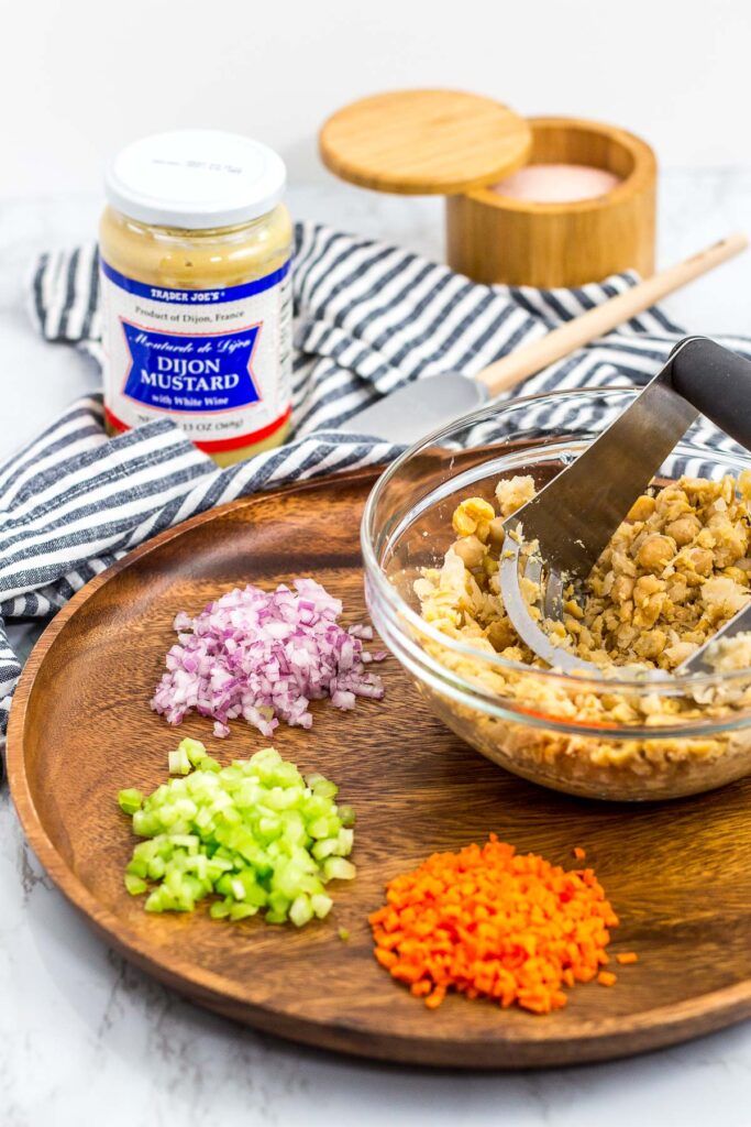 ingredients to make chickpea salad - mashed chickpea, onion, celery, carrot, dijon mustard and salt