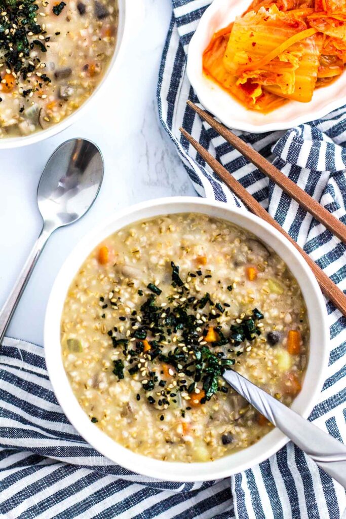 two bowls of vegan savory steel cut oatmeal with side of kimchi