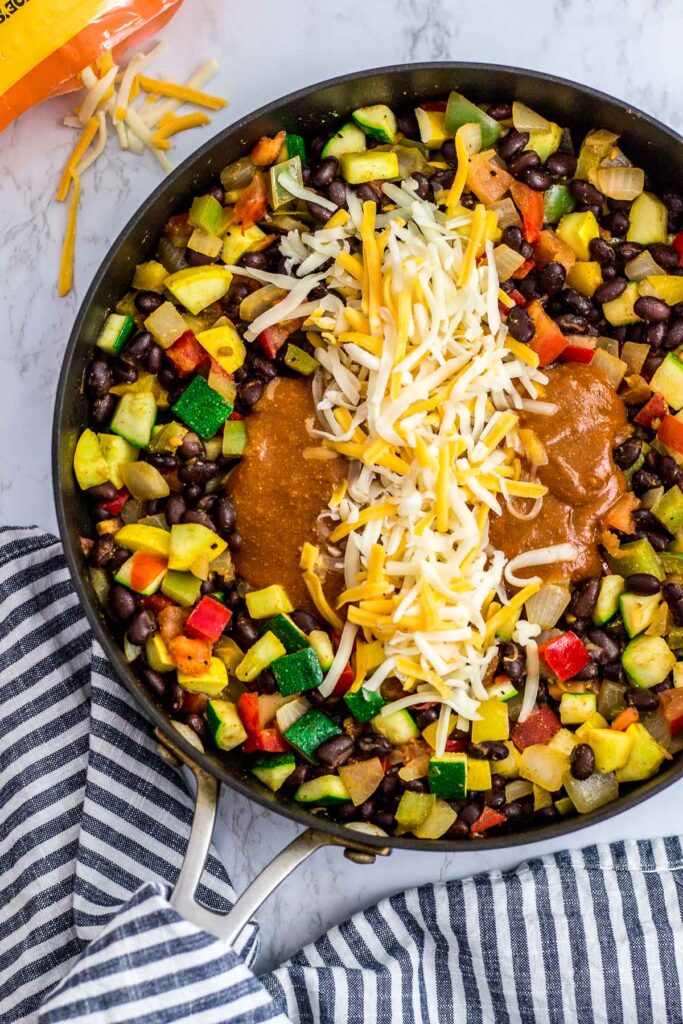 summer vegetables, red enchiladas sauce and shredded cheese filling for the enchiladas