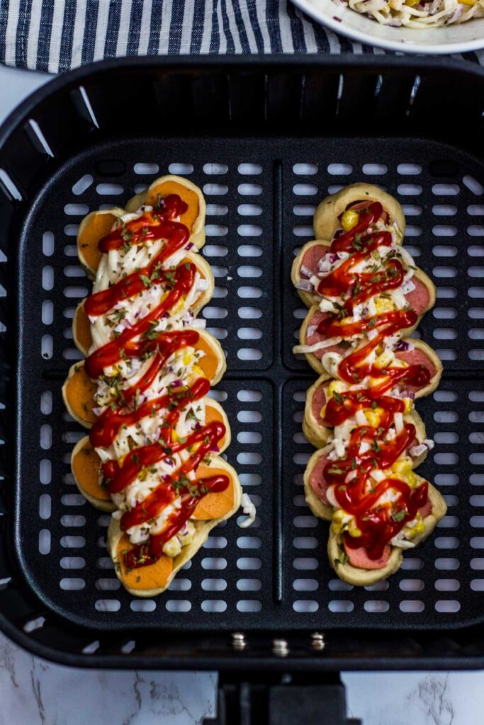 ketchup is drizzled on top of sausage bread before cooked in an air fryer