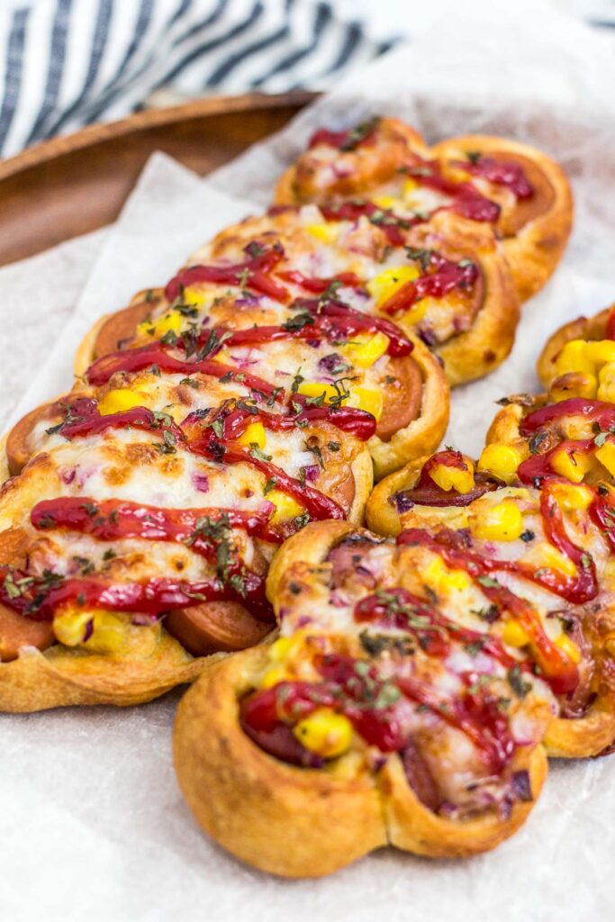 two Korean sausage bread on a wooden plate