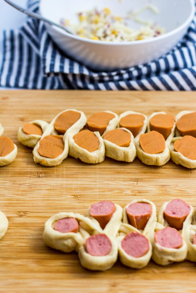 twist and flatten each section of the cut hot dog wrapped in crescent roll