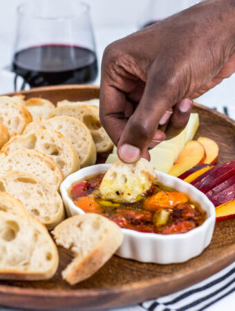 dipping baguette in cherry tomato and garlic oil