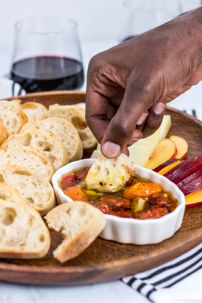 dipping baguette in cherry tomato and garlic oil