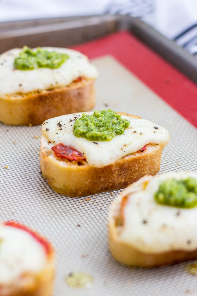 crushed roasted cherry tomato on top of baguette, topped with fresh mozzarella and pesto