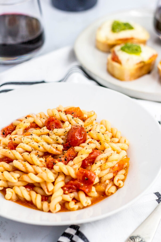 pasta with slow roasted cherry tomatoes and crostini in the background