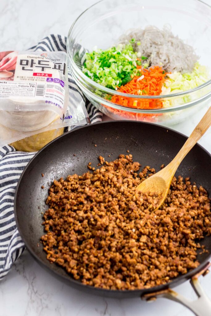 vegan beefless ground seasoned with bulgogi sauce, vegetables, Korean sweet potato noodles, and dumpling wrappers