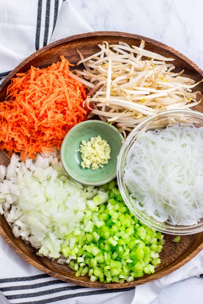 ingredients for vegan lumpia - bean sprouts, grated carrot, minced onion and celery, minced garlic, and vermicelli noodle