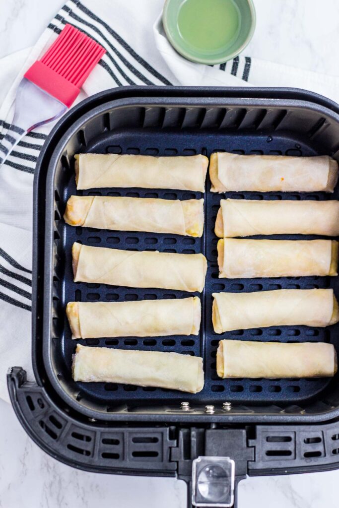 before picture of spring rolls in an air fryer basket