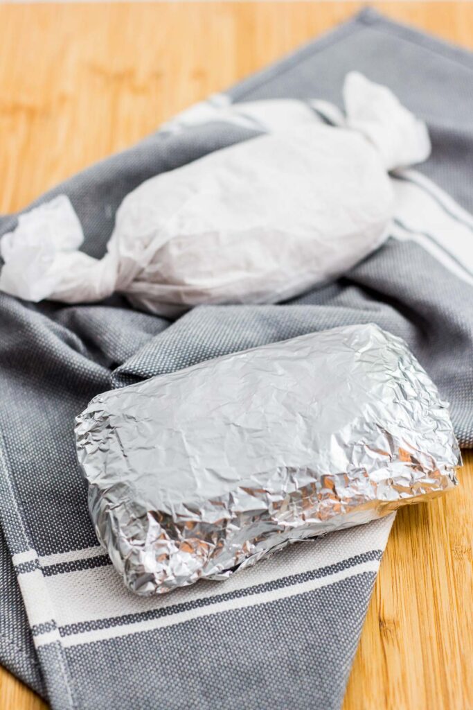 seitan one wrapped in parchment paper and one with foil