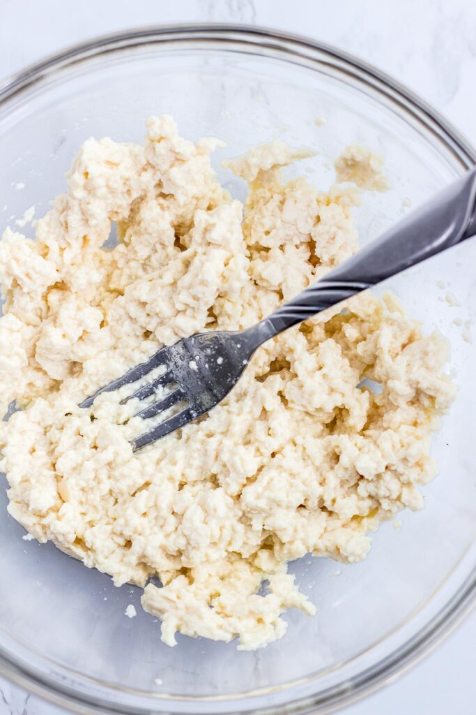 Mashed soft tofu with a fork