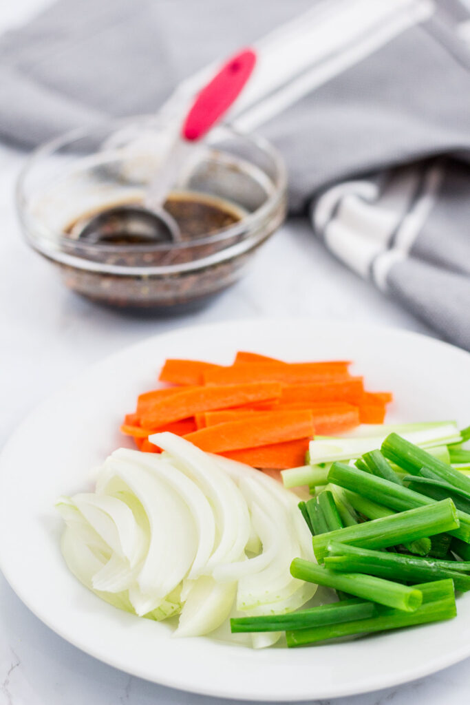 onion, carrot, green onion and bulgogi sauce in the bowl