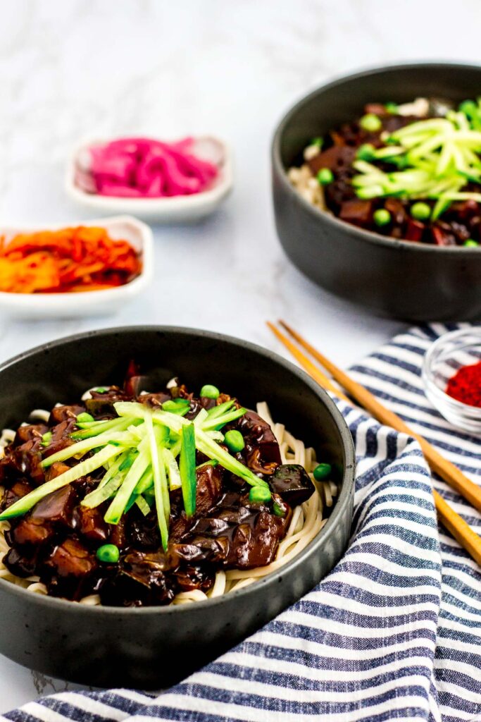 two bowls of vegan Korean black bean noodles