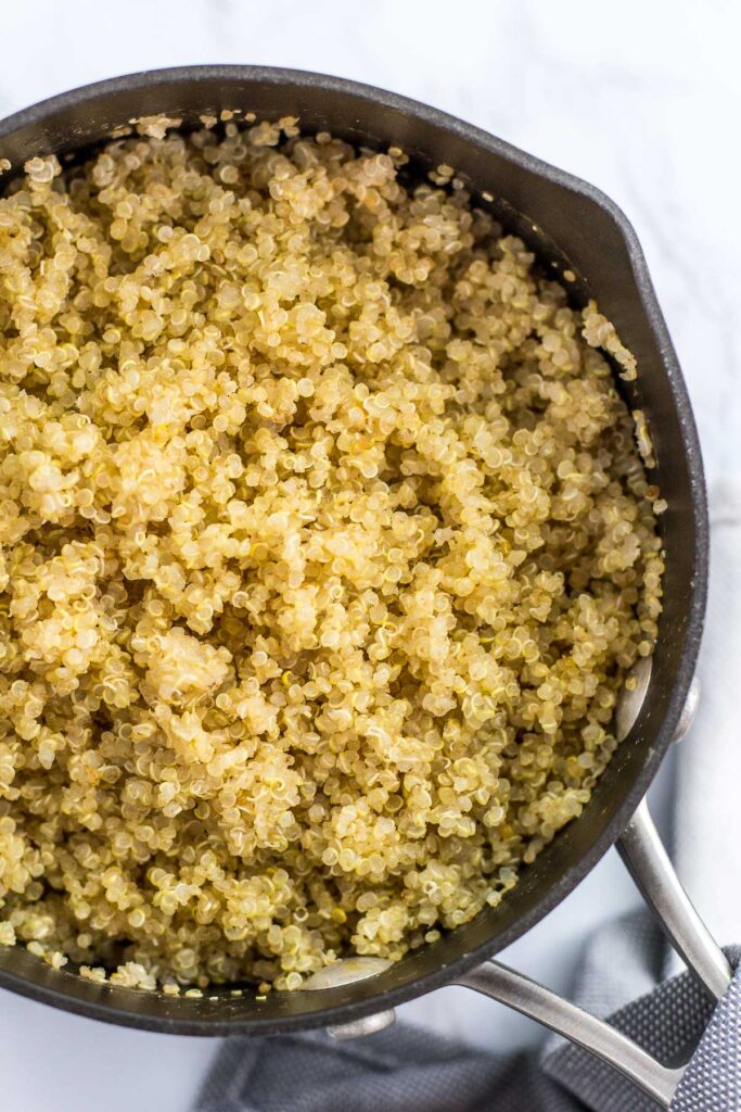 Cooked quinoa in the pot, fluffed with a fork