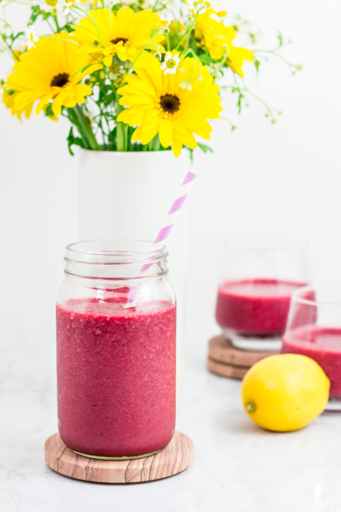 antioxidant-rich beetroot smoothie in a mason jar and two small glasses of smoothie in the background