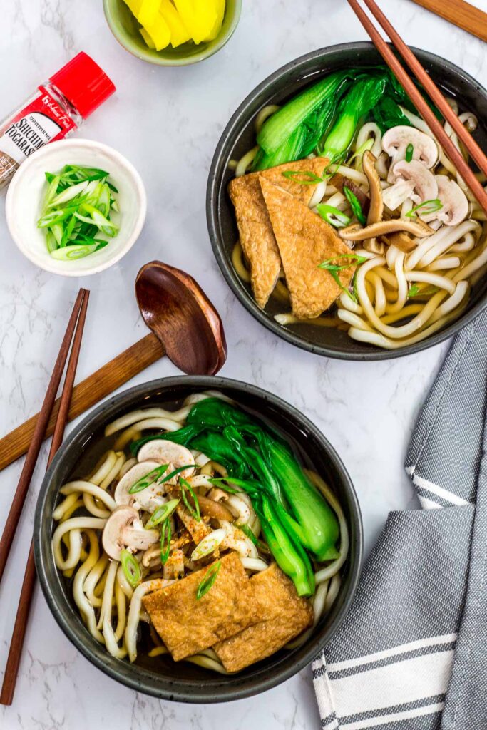 Overhead shot of two bowls of udon noodle soup