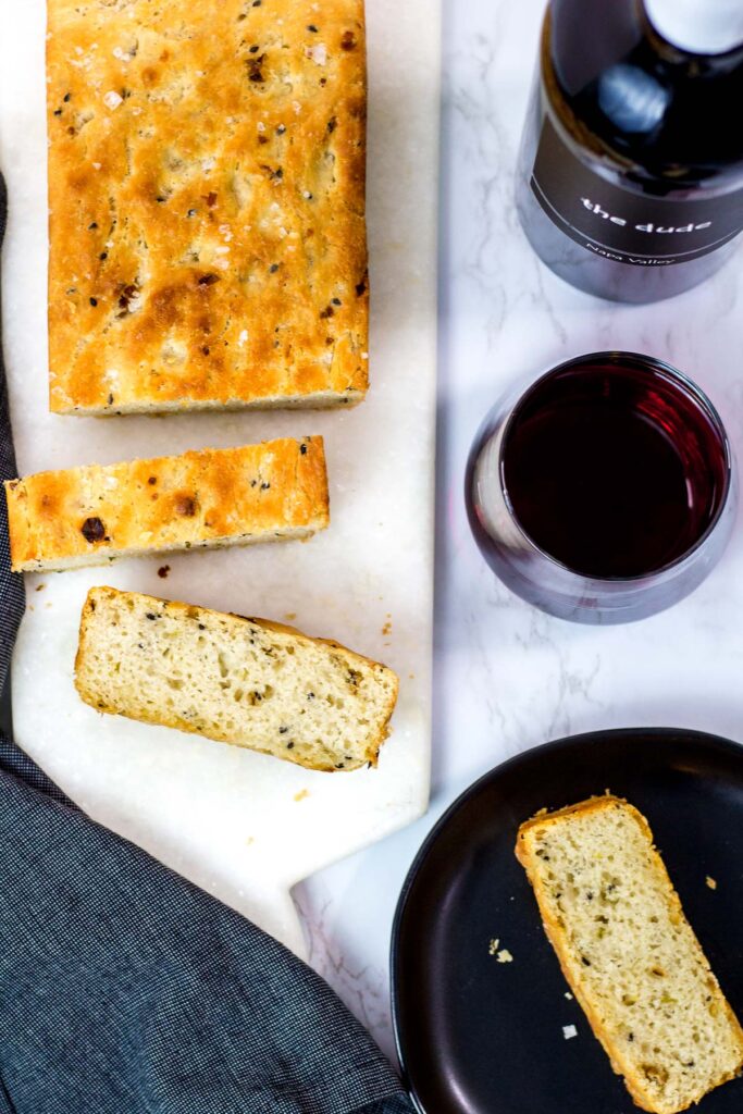 overhead shot of small batch garlic green onion focaccia with red wine