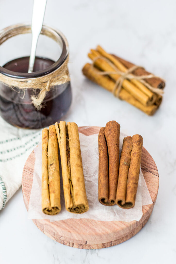 Cinnamon syrup in a glass jar and ceylon and cassia cinnamon sticks