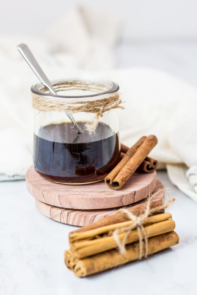 cinnamon syrup in a glass jar with cinnamon sticks