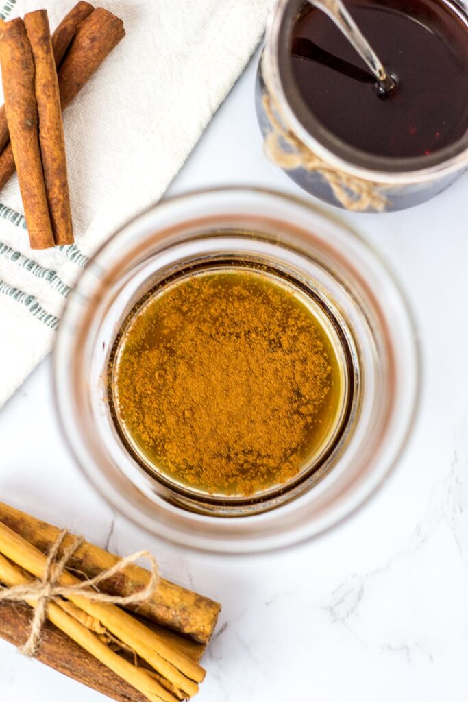 overhead shot of cinnamon syrup and cinnamon powder in a glass