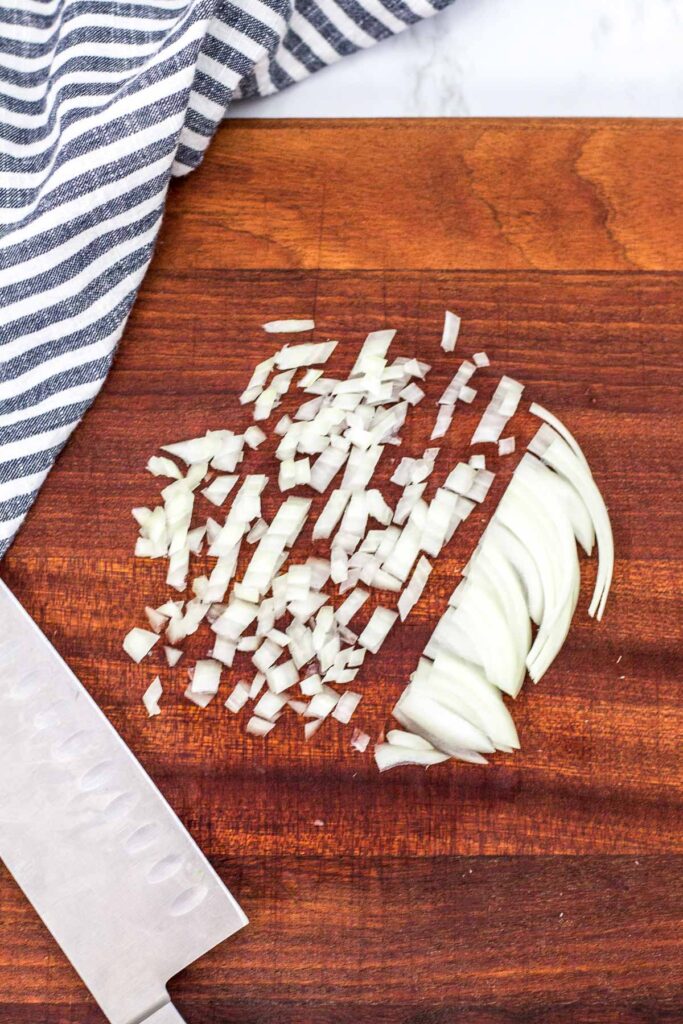 Minced onion on a wooden cutting board