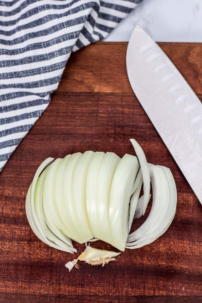 overhead shot of sliced onion, the beard part of the onion removed