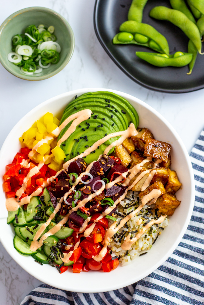 overhead shot of beet poke bowl with drizzle of spicy mayo