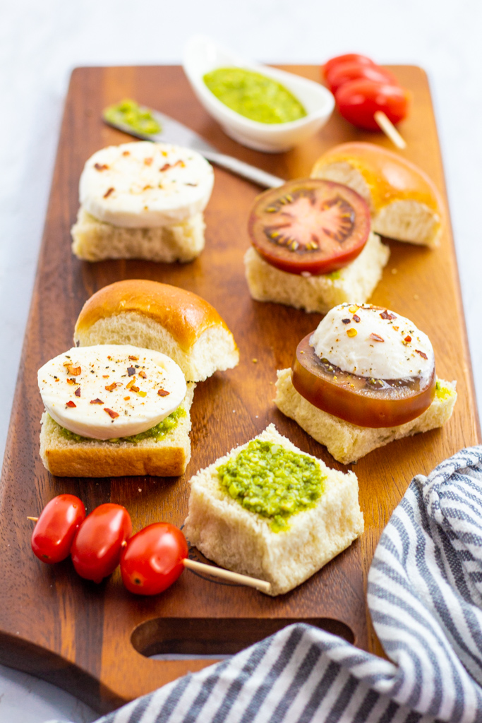 Caprese cold sliders in making on a wooden board