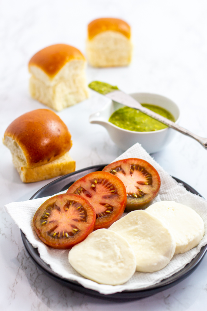 hawaiian buns, sliced tomato and fresh mozzarella cheese, and pesto