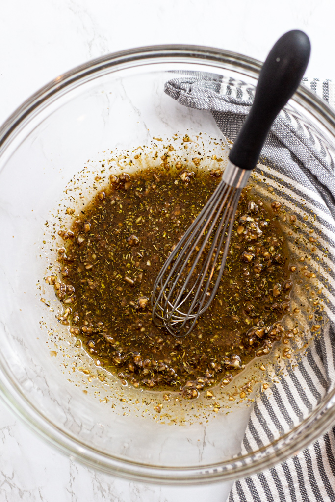 olive oil, balsamic vinegar, minced garlic, Dijon mustard, Italian herbs, and pepper in a bowl after mixing